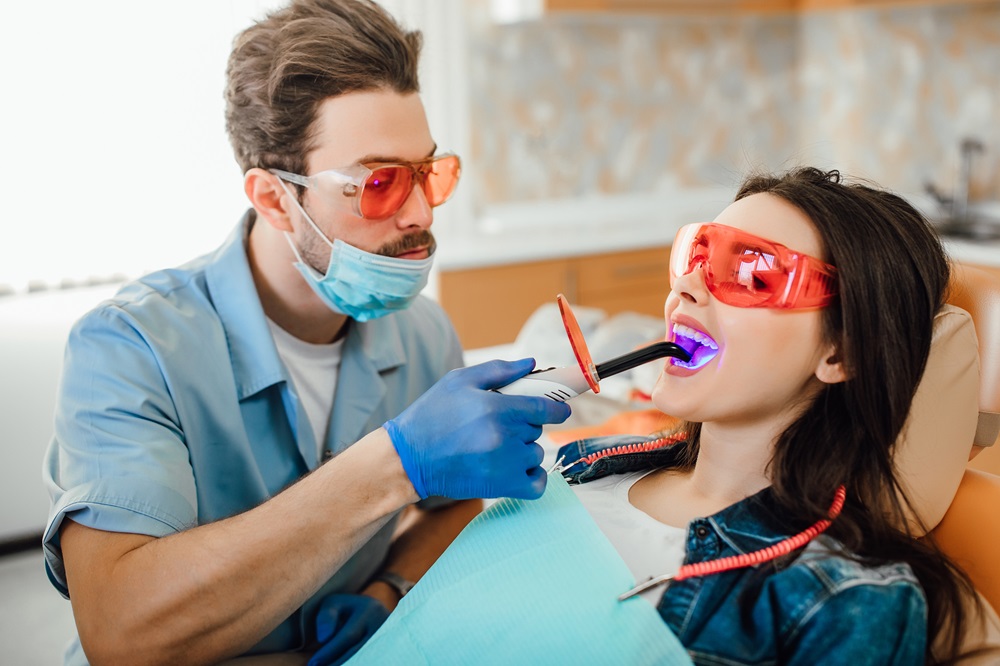 dentist performing teeth whitening treatment